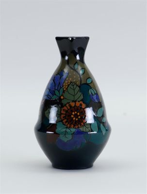 un vase noir orné d'un motif floral