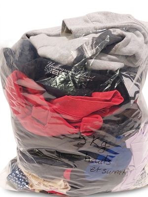 un sac rempli de vêtements, emballé dans du plastique