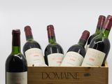 des bouteilles de vin rouge dans une caisse en bois avec un tire-bouchon