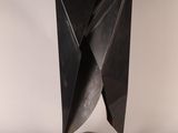 a black metal sculpture on a white surface with a white background
