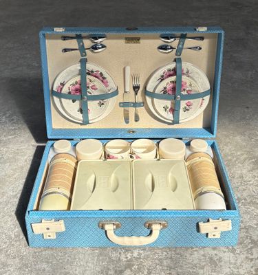a blue suitcase with a set of dishes and utensils in it
