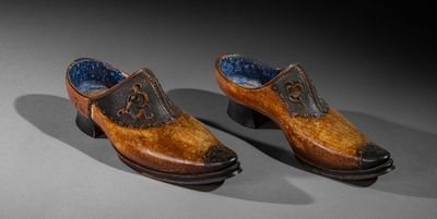 pair of wooden shoes with blue linings on a gray surface
