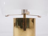 a brass table lamp with a clear glass shade on top