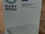 Le carton contenant le matelas Babymoov est posé sur la table.