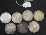 six different coins sitting next to each other on a black surface