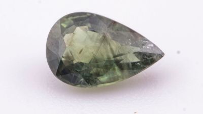 un gros plan d'une tourmaline verte sur une surface blanche