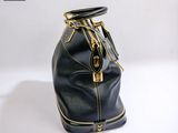 a black purse that is sitting on a white surface