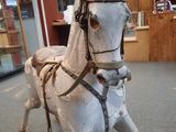 a wooden rocking horse that is sitting in a room