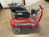 a small air compressor sitting on the floor in the garage