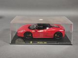 a red toy car in a clear box on a table