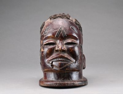 une image représentant un masque en bois orné d'un visage d'homme