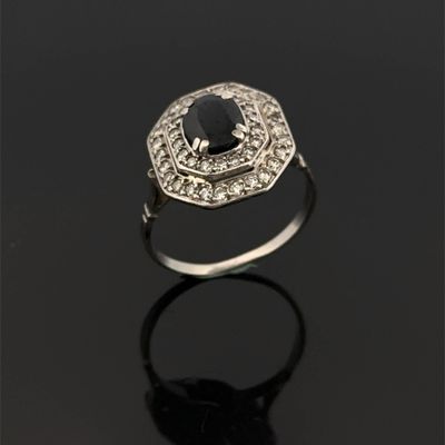 une bague en diamant noir et blanc posée sur une surface noire