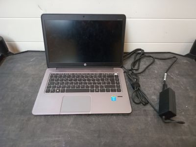 a laptop that is sitting on the floor next to a charger