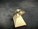 a close up of a gold ring with pearls on it