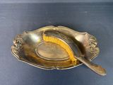 a silver plate with a brush in it on a blue surface