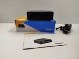 une boîte contenant une télécommande et un chargeur, posée sur une table