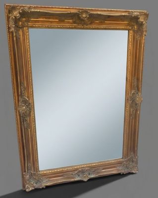 une image représentant un miroir à cadre doré sur fond gris