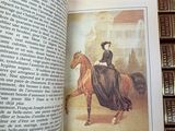 an open book with a picture of a woman riding a horse
