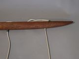 underside view of a wooden surfboard with a string attached to it