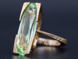 Gros plan sur une bague contenant une pierre verte