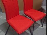 pair of red chairs with black legs in a room