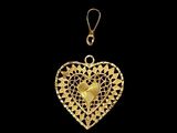 a gold heart shaped pendant with black and white dots on it