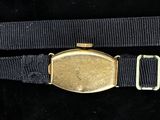 a gold watch on a black belt with a gold buckle