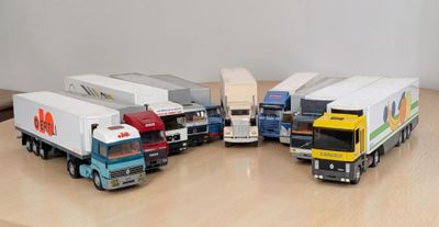 Plusieurs camions miniatures sont alignés sur une table en bois