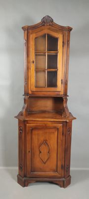 a wooden cabinet with a glass door on top of it