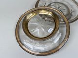 two clear glass plates with gold rims on a white table
