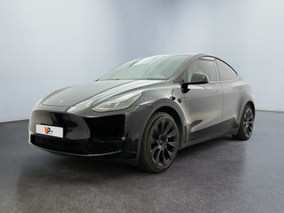 a grey tesla suv parked in a room with a black floor