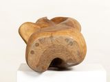 a wooden sculpture of a cat sitting on a white pedestal