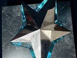 a silver and blue star on top of a silver plate