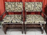 pair of carved wood chairs with floral upholstered cushions