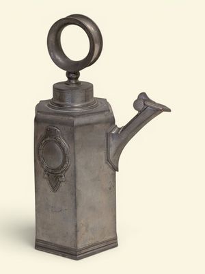 a metal watering can with a bird on it