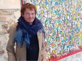 un homme debout devant un mur sur lequel est peinte une peinture