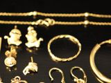 a lot of gold jewelry on a black table