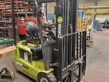 a forklift in a warehouse with pallets in the background