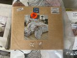 a pile of bedding on a bed with a picture of a zebra on it