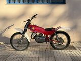 a red and white motorcycle parked in front of a building