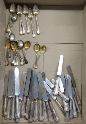 a lot of silver spoons and knives in a box