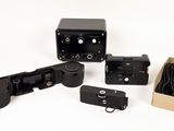 four cameras and a box on a white surface