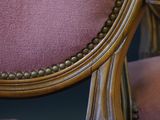 a close up of a chair with a pink upholstered seat
