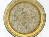 an image of a gold plate with a decorative design on it