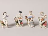 four figurines of children playing musical instruments on a white surface