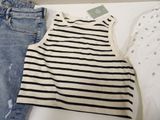 two pairs of jeans and a tank top are on a table