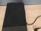 a black stove top with two burners and a power cord