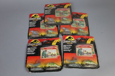 Six dinosaures en peluche sont dans un paquet posé sur une table