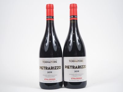 deux bouteilles de vin rouge sont posées côte à côte sur une surface blanche