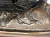 a bronze statue of a horse and a bird on it